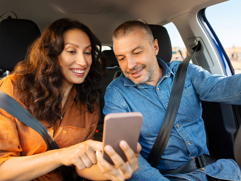 A couple traveling with their phones in a car